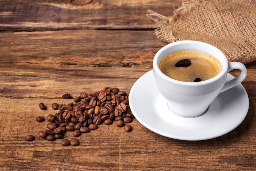 taza-cafe-sobre-mesa-madera-muro-oscuro_155003-8192